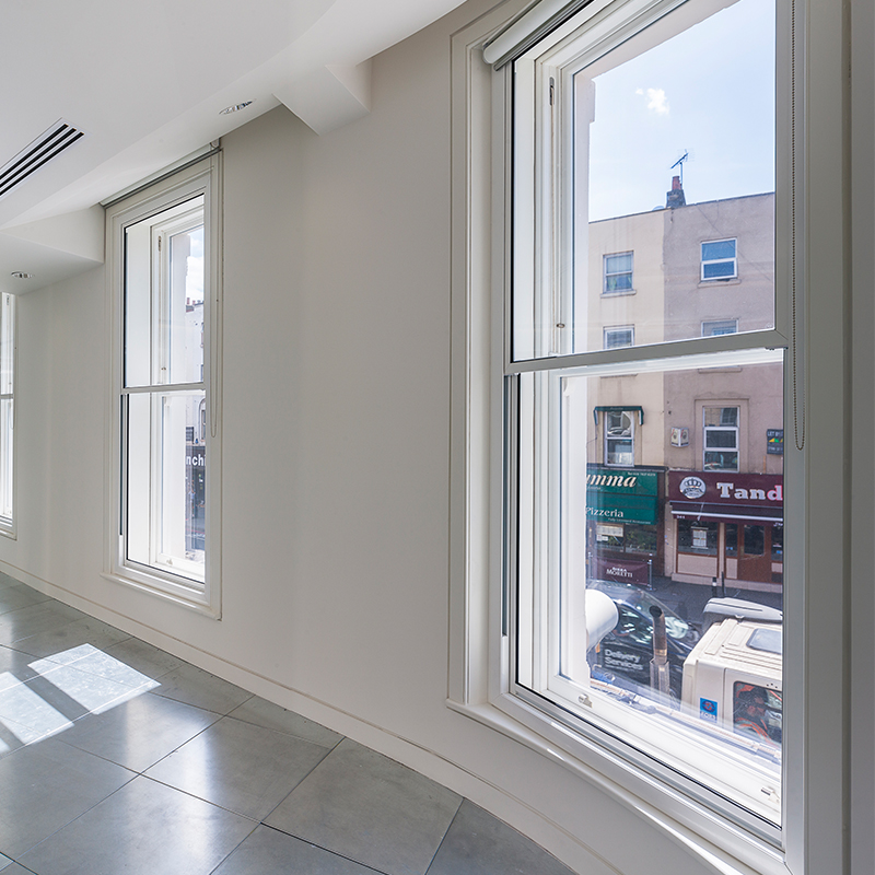 Vertical sliding secondary glazing with minimal frames to blend into the original frames