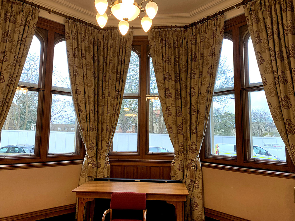 The windows in their full glory, creating a warm and quiet meeting space, with Selectaglaze timber grain effect secondary glazing