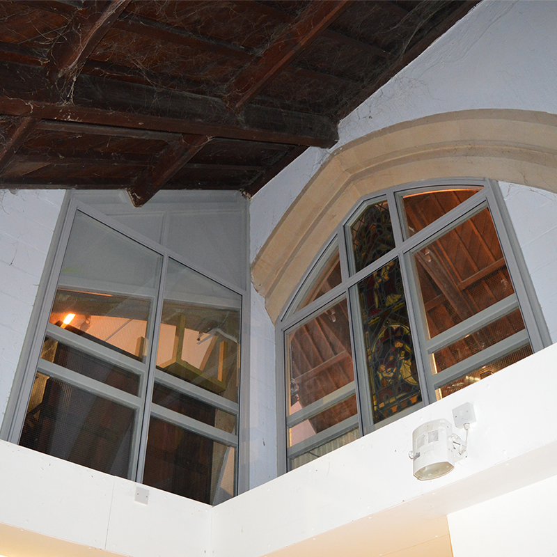 Internal windows with acoustic secondary glazing overlooking the ground floor worship area with secondary glazing