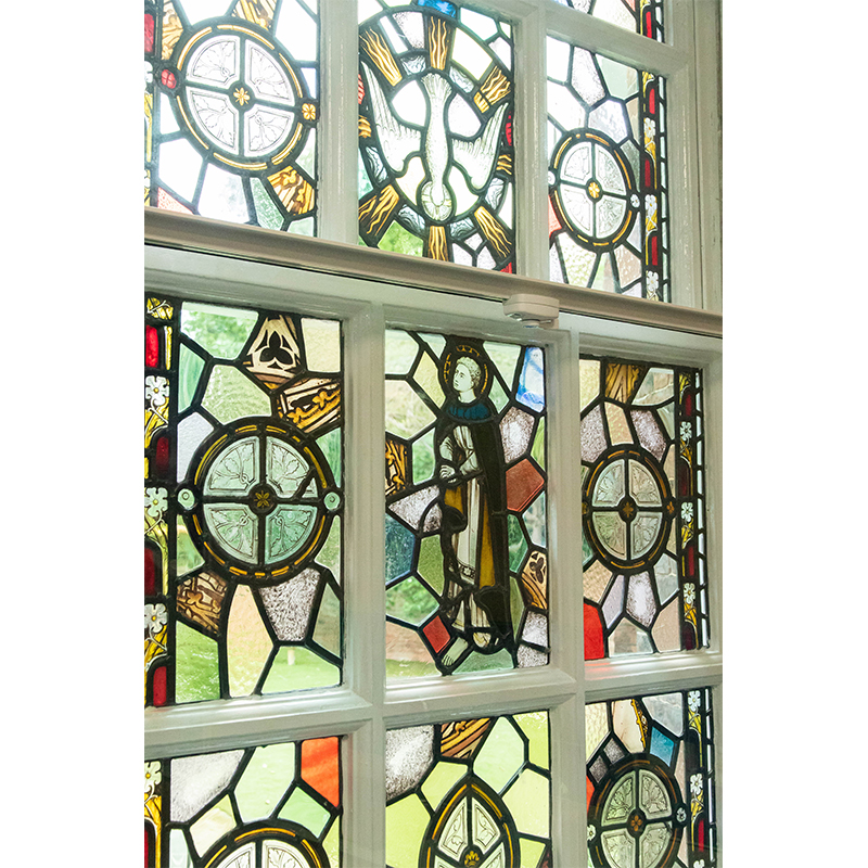 Secondary glazing with a fitch catch in front of decorative stained glass original window