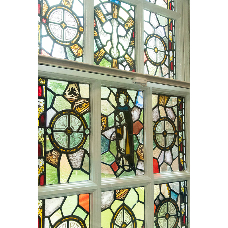 Secondary glazing with a fitch catch in front of decorative stained glass original window