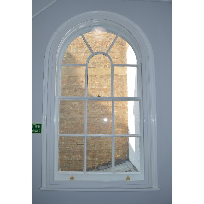Arched head secondary glazing in the corridor at a Grade II Listed building in Cambridge