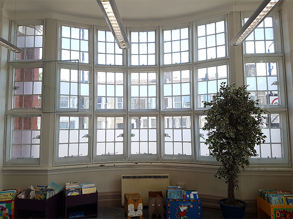 The original secondary glazed sweeping bay window at Plumstead Library, where each unit was independently fixed directly into the stone work