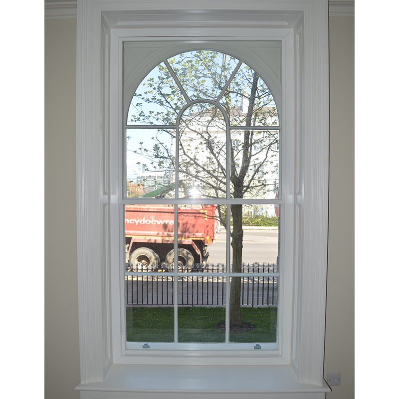 Secondary glazing against an arched head primary window, fitted within the newly created extended shutter box