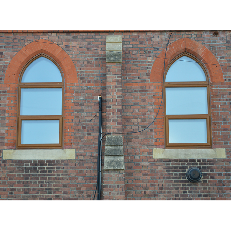 Close up of the external view of the arched windows at this south London church which needed secondary glazing to reduce noise escapement
